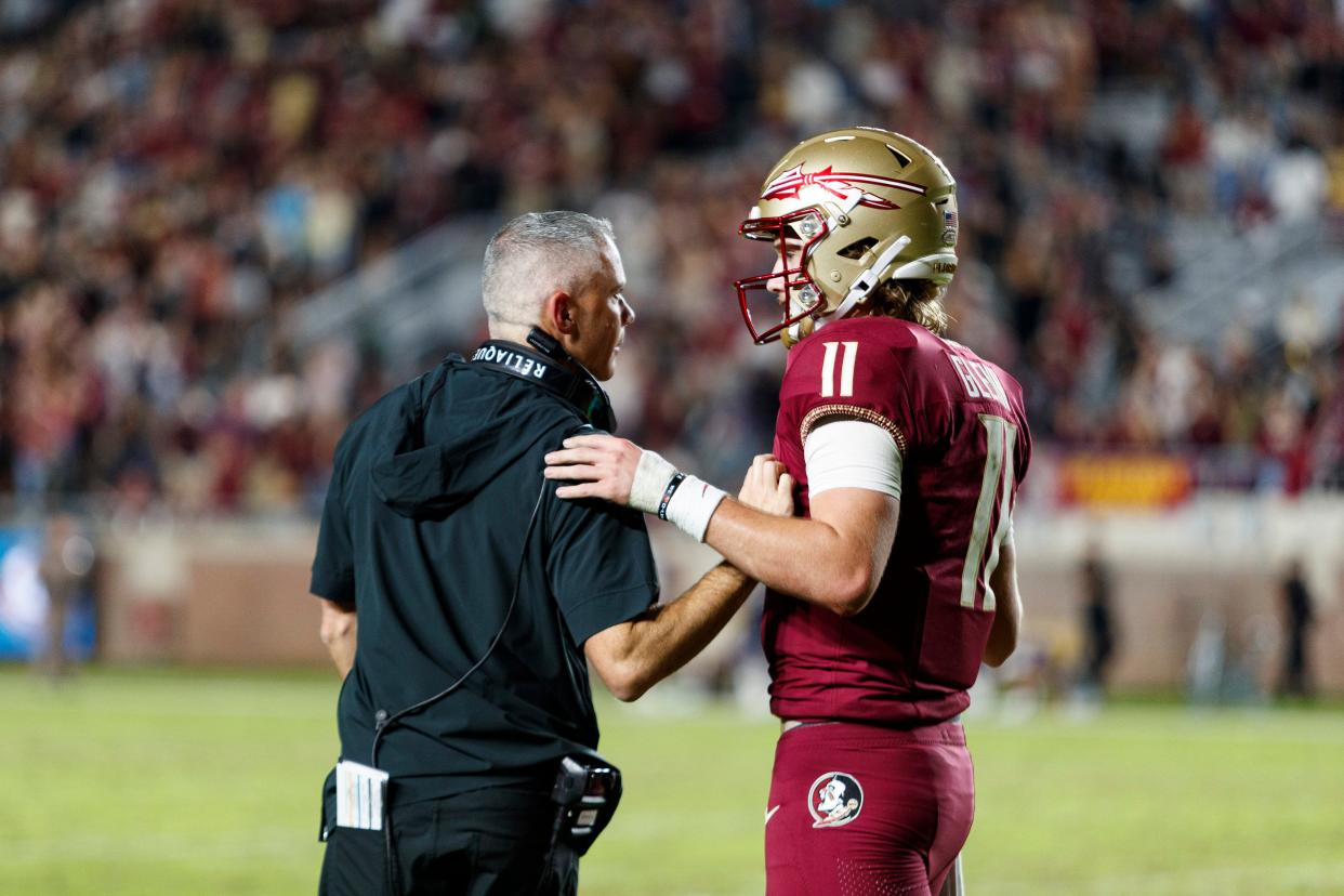 Nov 18, 2023; Tallahassee, Florida, USA; Florida State Seminoles quarterback Brock Glenn (11) and head coach Mike Norvell talk after a play during the fourth quarter at Doak S. Campbell Stadium.