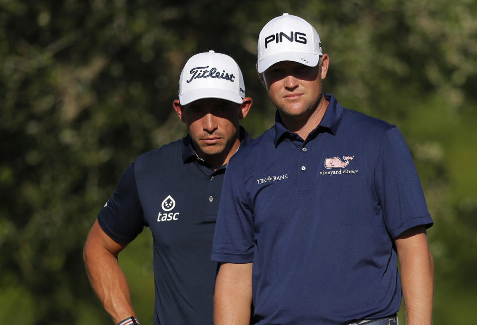 Scott Stallings, left, and Trey Mullinax wait for their turn to putt during the first round of the PGA Zurich Classic golf tournament at TPC Louisiana in Avondale, La., Thursday, April 25, 2019. (AP Photo/Gerald Herbert)