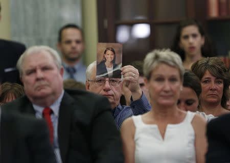 A family member displays a photo of one of the victims of General Motors' ignition/air bag failure at the Senate Commerce, Science and Transportation Subcommittee in Washington July 17, 2014. REUTERS/Gary Cameron
