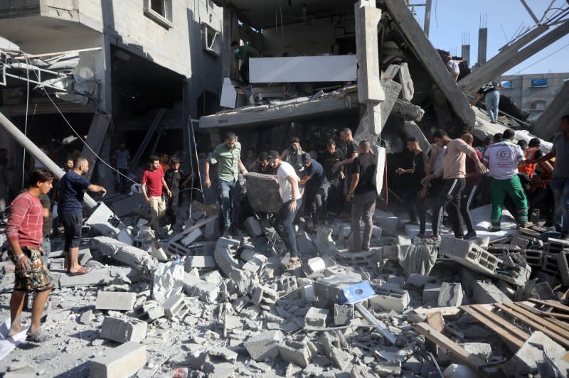 Rescuers sift through the rubble of a collapsed house following an Israeli airstrike on Rafah in southern Gaza Strip on Thursday. Photo by Ismael Mohamad/UPI