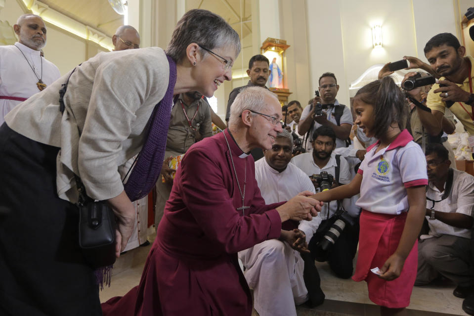 The Archbishop of Canterbury Justin Welby blesses a survivor of the Easter Sunday attack at St. Sebastian's church in Katuwapitiya village, Negombo , Sri Lanka, Thursday, Aug. 29, 2019. The figurehead of the Church of England emphasized the need for Christian unity on Thursday as he paid tribute to the victims of the Easter Sunday bomb attacks at a Roman Catholic church in Sri Lanka. A total of 263 people were killed when seven suicide bombers from a local Muslim group attacked three churches and three luxury hotels on April 21. (AP Photo/Eranga Jayawardena)