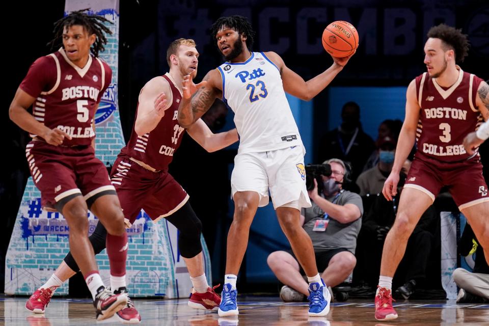 Pittsburgh's John Hugley (23) looks to pass against Boston College's James Karnik (33) during the first half of an NCAA college basketball game of the Atlantic Coast Conference men's tournament, Tuesday, March 8, 2022, in New York. (AP Photo/John Minchillo)