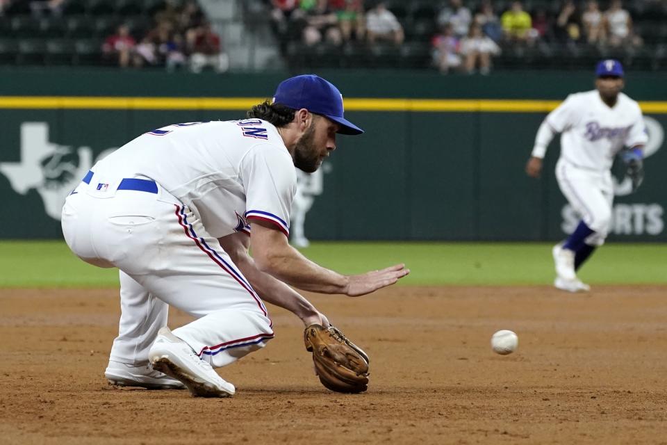 Texas Rangers third baseman Charlie Culberson reaches down to field a grounder by Houston Astros' Chas McCormick, who was out at first during the second inning of a baseball game in Arlington, Texas, Tuesday, Sept. 14, 2021. (AP Photo/Tony Gutierrez)