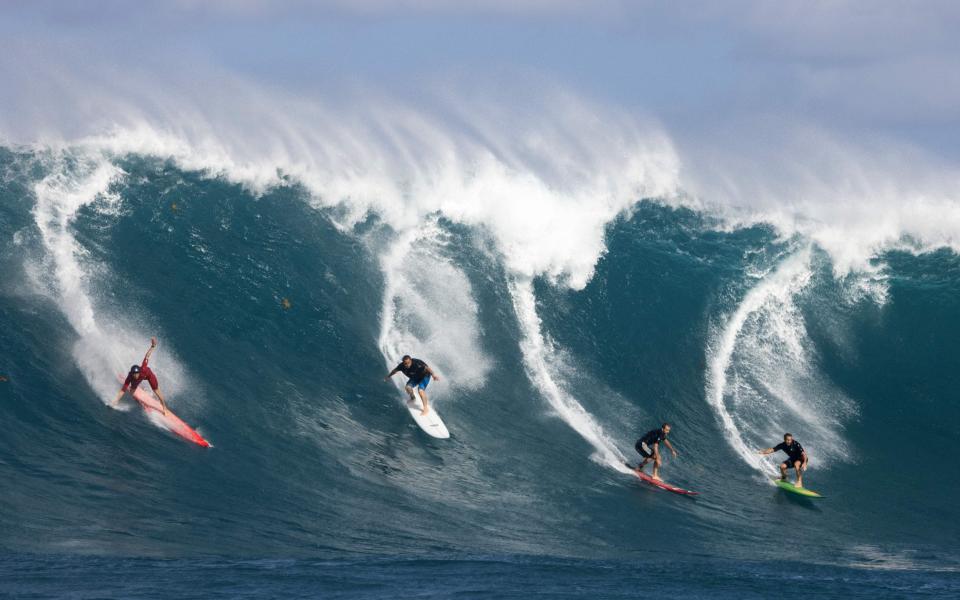 Watch surfers ride the big waves at Waimea Bay