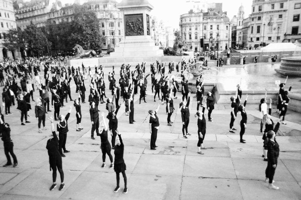 A group of performers raise their arms to the sky in Trafalgar Square. (Cafe Art/SWNS)