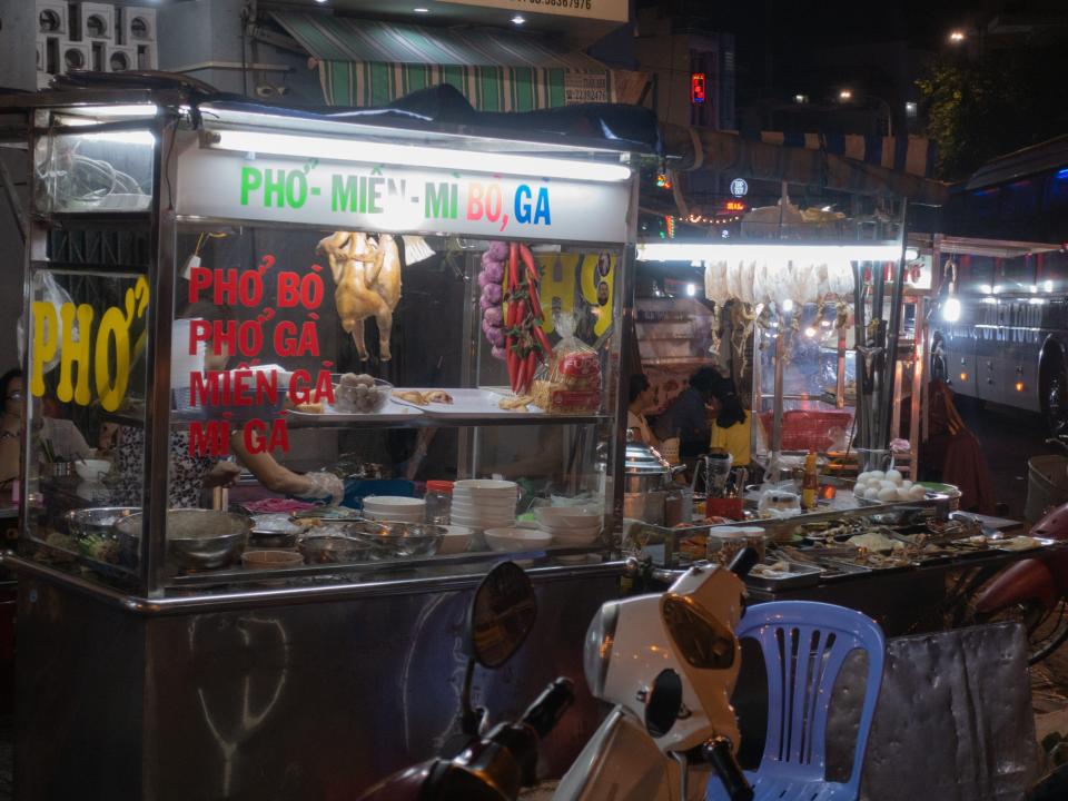 A vendor selling pho at a late-night street-food market in Ho Chi Minh City, Vietnam.