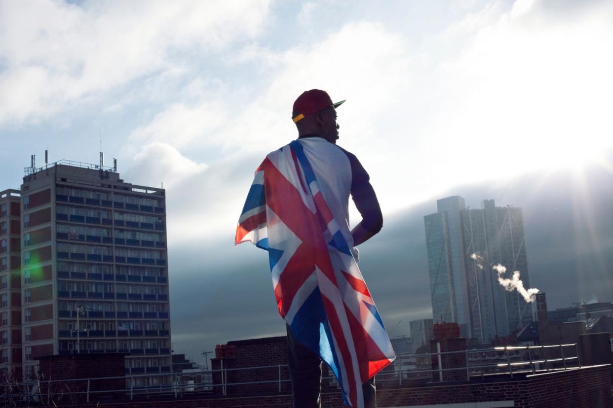 Black man holding UK flag