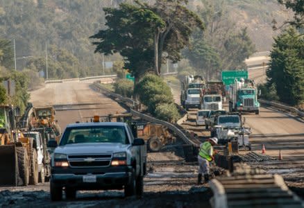 Workers on the 101 Highway clear mud and debris from the roadway after a mudslide in Montecito, California, U.S. January 12, 2018.  REUTERS/Kyle Grillot