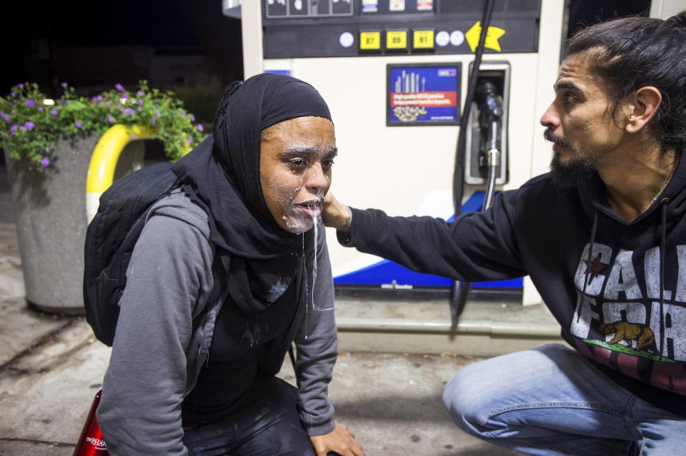 A protester recovers from teargas exposure during a protest against police violence in the U.S., in Berkeley