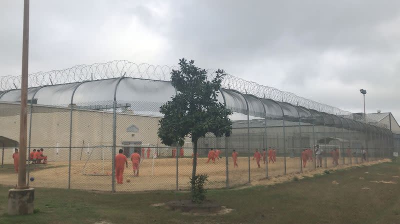 Detained immigrants play soccer behind a barbed wire fence at the Irwin County Detention Center in Ocilla