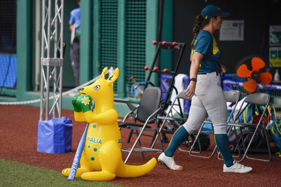 Australia's Kaia Parnaby walks past the team mascot, a boxing kangaroo, to the team dug out during the softball game between the Italy and Australia at the 2020 Summer Olympics, Thursday, July 22, 2021, in Fukushima , Japan. (AP Photo/Jae C. Hong)