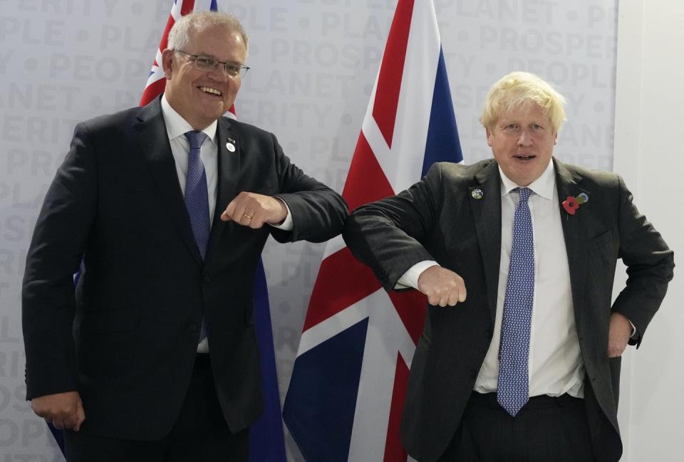 two men in suits touch elbows