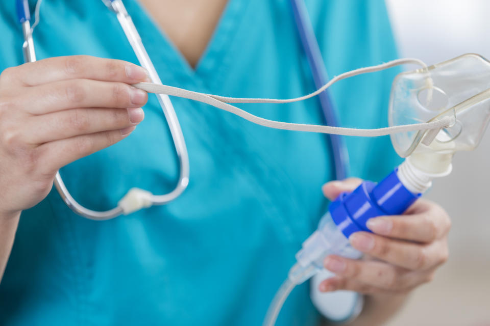 A nurse holds a nebuliser.