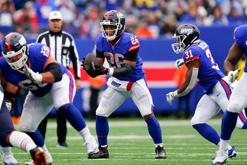 New York Giants running back Saquon Barkley (26) takes a snap at quarterback in the fourth quarter during Sunday's game against the Chicago Bears.