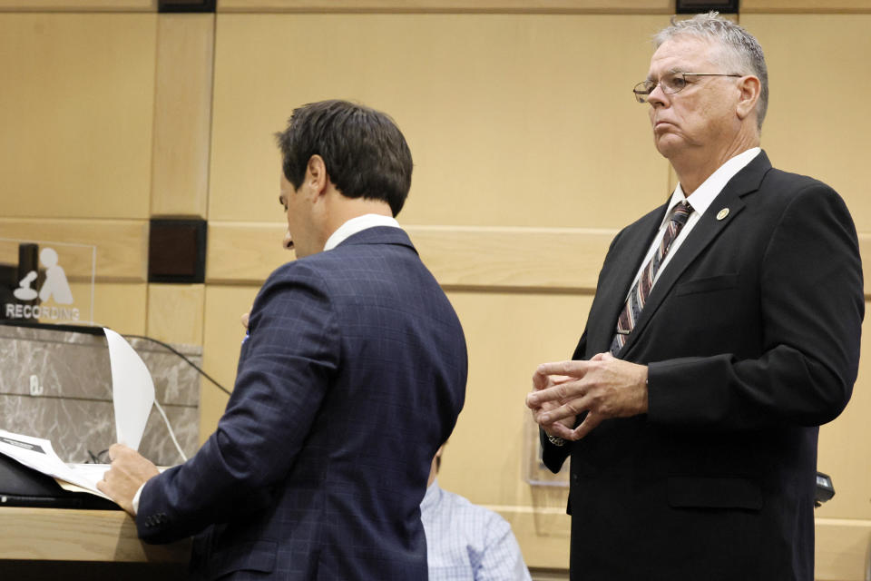 Former Marjory Stoneman Douglas High School School Resource Officer Scot Peterson, right, stands behind his defense lawyer Mark Eiglarsh during a hearing in his case at the Broward County Courthouse in Fort Lauderdale, Fla., Monday, May 22, 2022. Broward County prosecutors charged Peterson, a former Broward Sheriff's Office deputy, with criminal charges for failing to enter the 1200 Building at the school and confront the shooter, Nikolas Cruz, during a mass shooting at the Parkland high school five years ago. (Amy Bennett/South Florida Sun-Sentinel via AP, Pool)