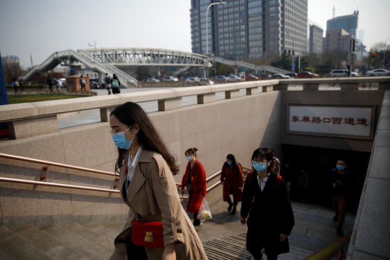 People wearing face masks exit a subway station following an outbreak of the coronavirus disease (COVID-19), in Beijing