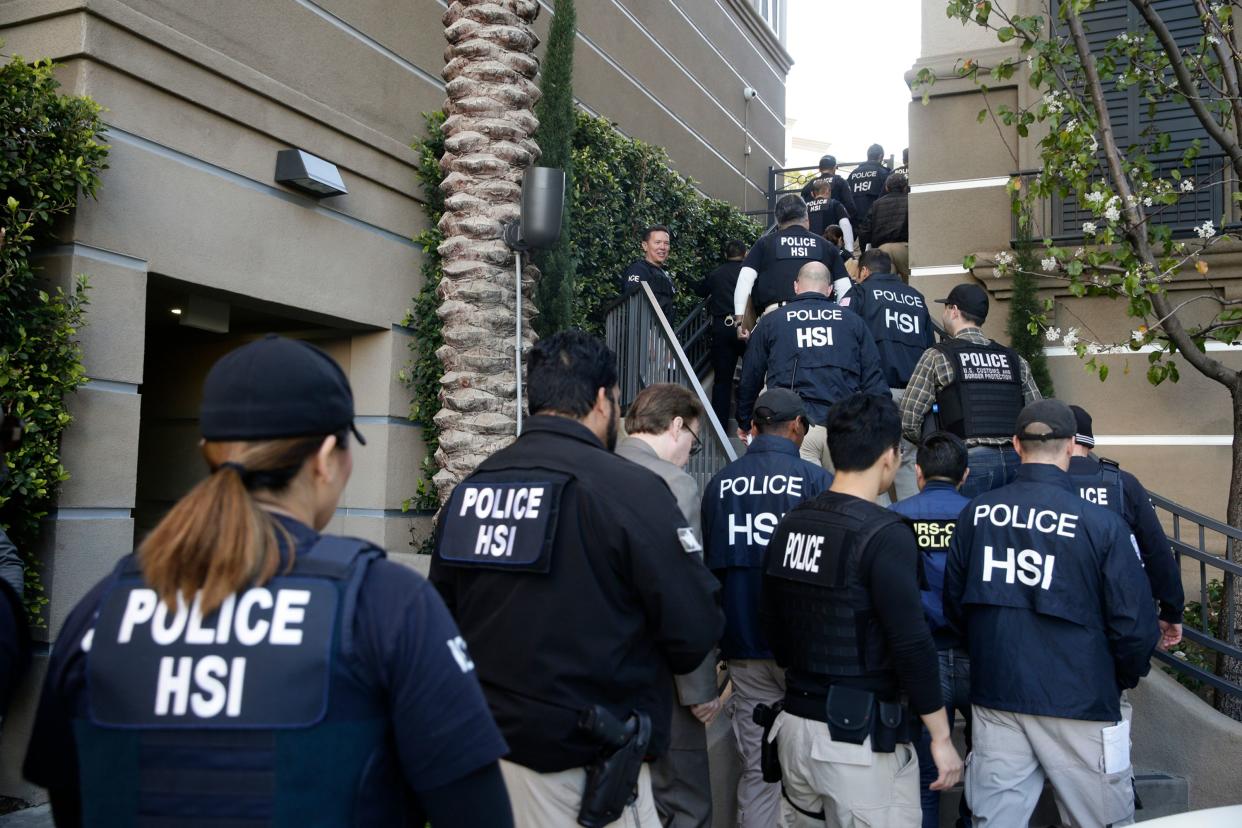 In this 2015 file photo, federal agents enter an upscale apartment complex where authorities say a birth tourism business charged pregnant women $50,000 for lodging, food and transportation, in Irvine, Calif. On  Jan. 31, 2019, authorities announced they have charged 20 people in an unprecedented crackdown on the businesses.