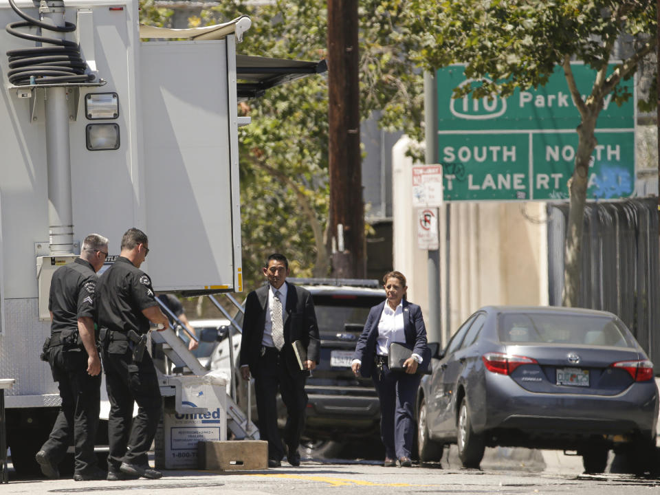 FILE - In this Saturday, July 27, 2019 file photo police officers investigate the killing of a fellow officer in the Lincoln Heights area of Los Angeles. The primary suspect in the fatal shooting of an off-duty Los Angeles police officer was arrested early Friday, Aug. 2, a person briefed on the investigation told The Associated Press. (AP Photo/Damian Dovarganes,File)