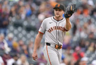 San Francisco Giants starting pitcher Keaton Winn catches new ball after giving up an RBI double to Colorado Rockies' Sean Bouchard in the fourth inning of a baseball game Thursday, May 9, 2024, in Denver. (AP Photo/David Zalubowski)