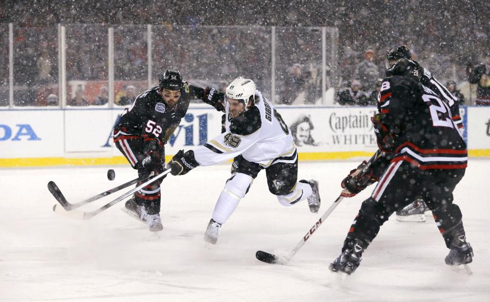 Pittsburgh Penguins center Brian Gibbons (49) has his shot deflected by Chicago Blackhawks left wing Brandon Bollig during the first period of an NHL Stadium Series hockey game at Soldier Field on Saturday, March 1, 2014, in Chicago. (AP Photo/Charles Rex Arbogast)