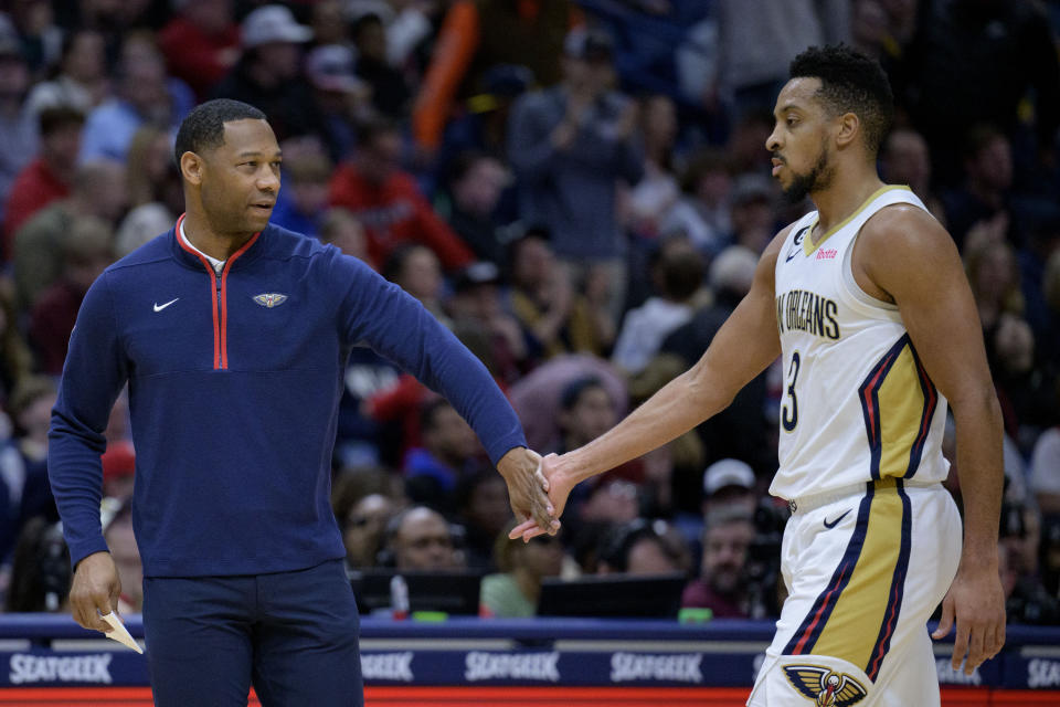 New Orleans Pelicans head coach Willie Green, left, low-fives New Orleans Pelicans guard CJ McCollum (3) in the first half of an NBA basketball game against the Indiana Pacers in New Orleans, Monday, Dec. 26, 2022. (AP Photo/Matthew Hinton)