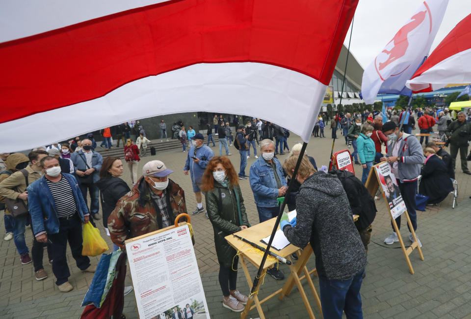 People, wearing face masks to protect against coronavirus, queue up to sign up to support potential presidential candidates in the upcoming presidential elections in Minsk, Belarus, Sunday, June 14, 2020. The presidential campaign is underway in Belarus despite the coronavirus outbreak after the parliament and government refused to postpone the election scheduled for August 9. (AP Photo/Sergei Grits)