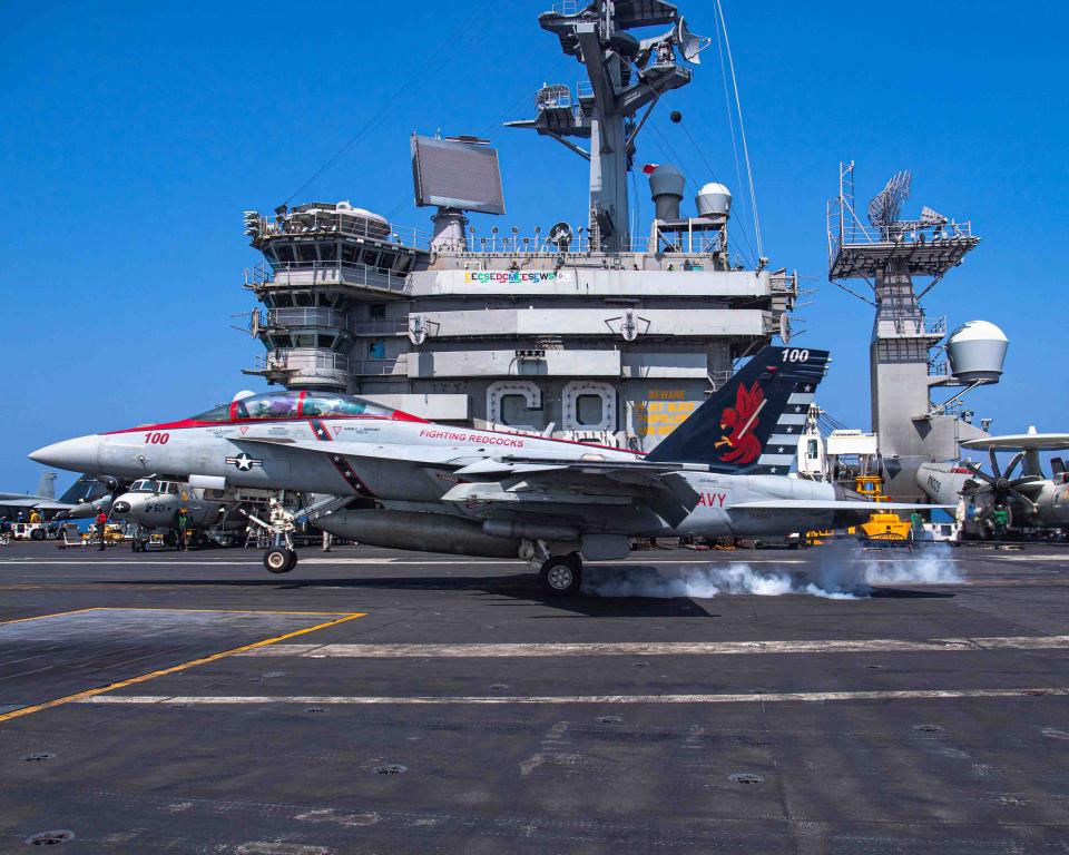 US Navy Capt. Craig Sicola, commanding officer of the aircraft carrier USS Nimitz (CVN 68), front seat, and Cmdr. Luke Edwards, commanding officer of the “Fighting Redcocks” of Strike Fighter Squadron (VFA) 22, make an arrested landing in an F/A-18F Super Hornet from VFA-22 marking the 350,000th time the carrier has landed a fixed-wing aircraft on its flight deck.