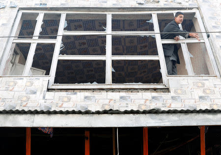 An Afghan man removes broken glass from a window after a car bomb blast in Kabul, Afghanistan January 15, 2019.REUTERS/Mohammad Ismail
