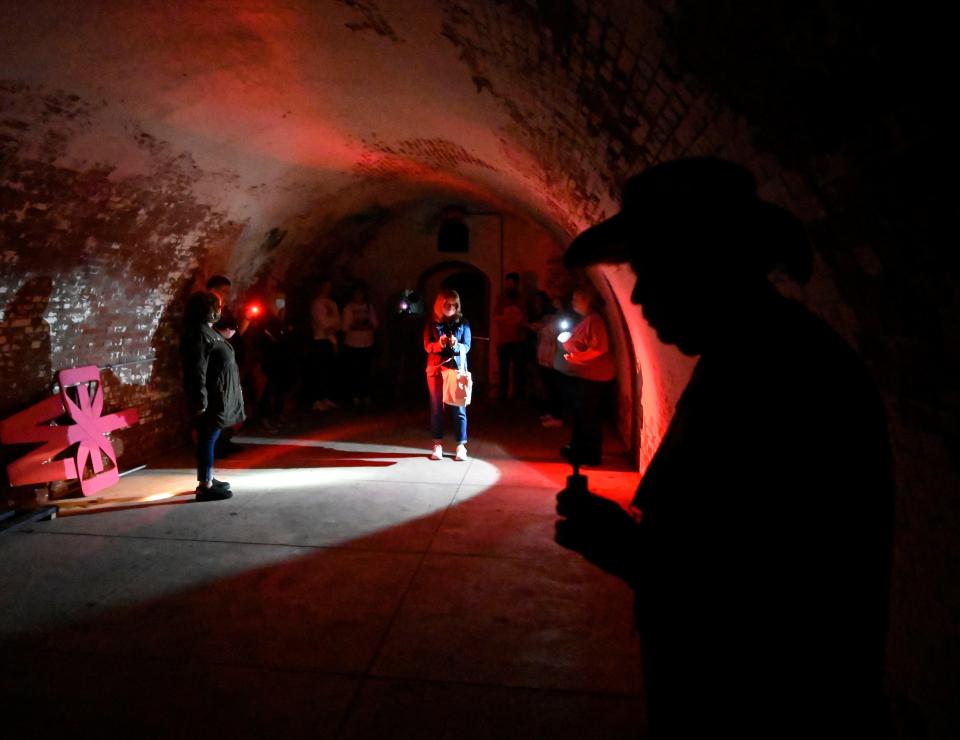 Guests explore the Gunpowder Room during a paranormal event at Fort Mifflin in Pennsylvania.