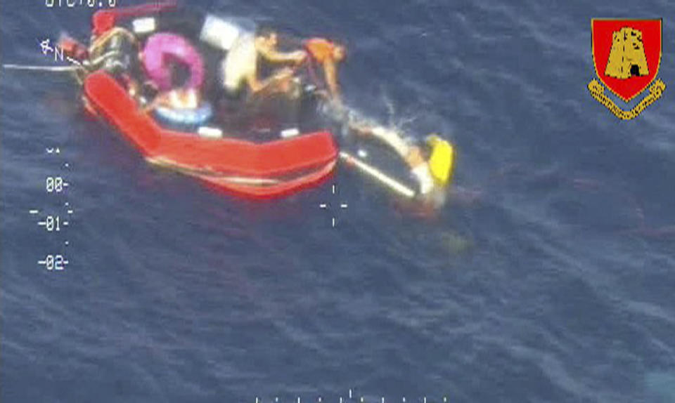 Migrants climb aboard a life raft deployed by an Armed Forces of Malta aircraft