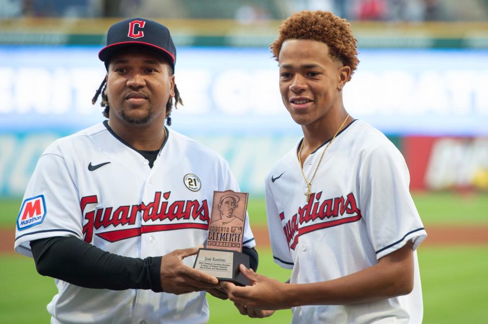 Cleveland Guardians' Jose Ramirez, left, holds the Roberto Clemente award with Andrhis Martinez of the Dominican Republic before a game Friday against the Texas Rangers in Cleveland.