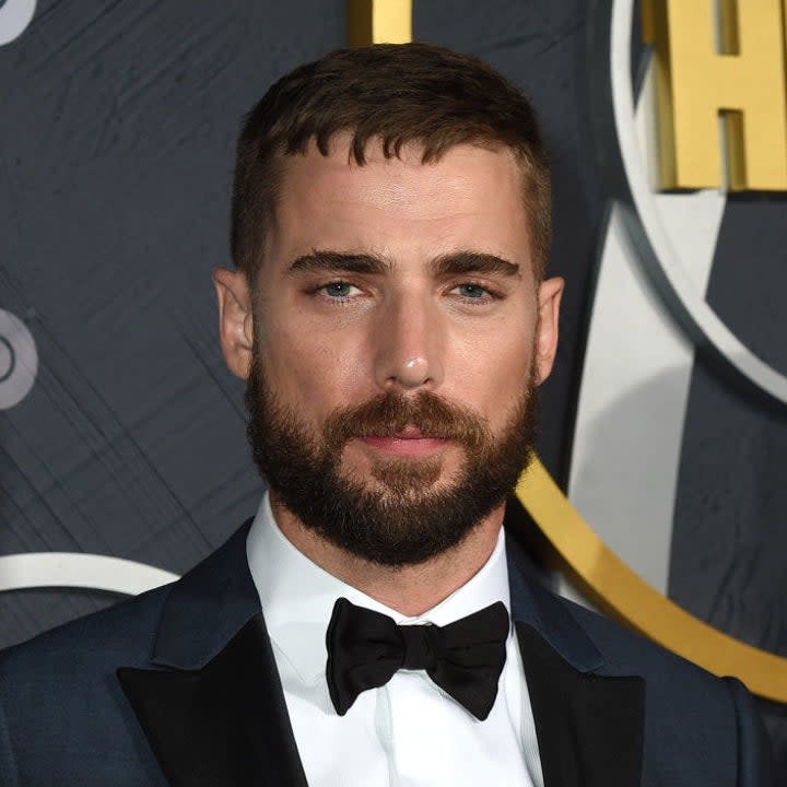 Dustin Milligan posing on a red carpet