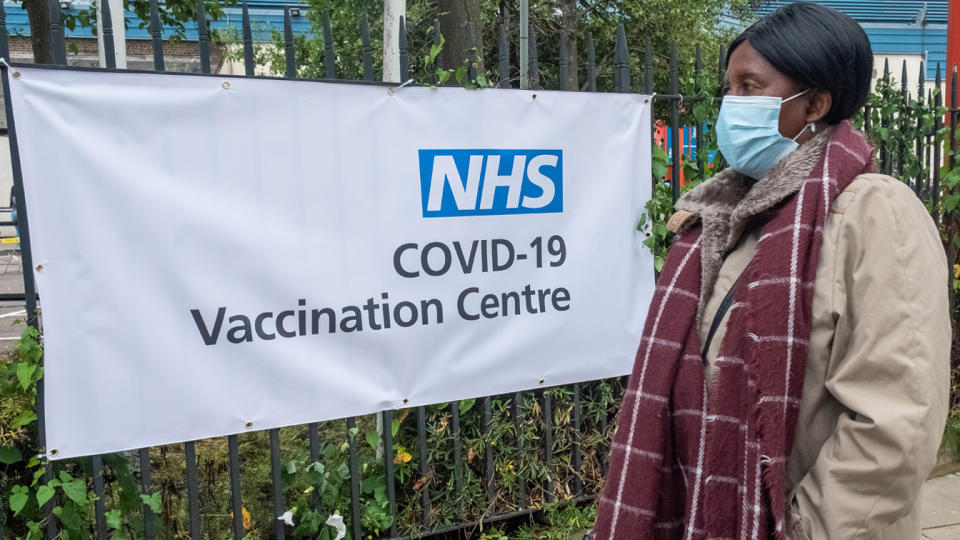 A woman walks past a sign of COVID-19 vaccination center in Brent, northwest London, Britain, June 19, 2021. (Ray Tang/Xinhua via Getty Images)