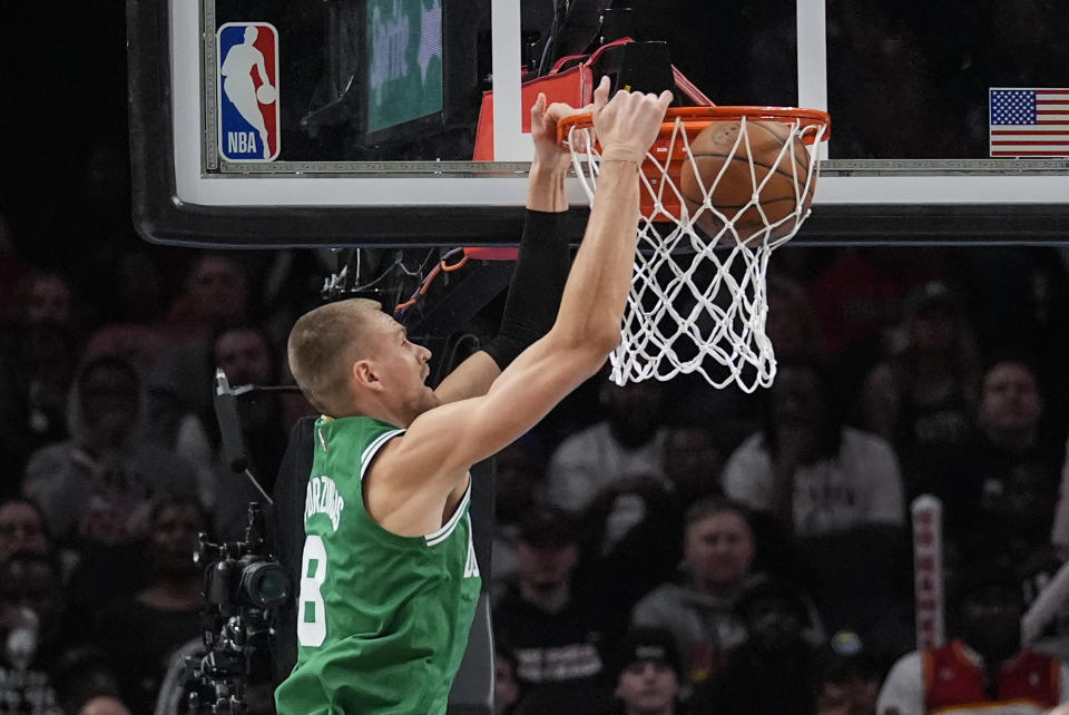 Boston Celtics center Kristaps Porzingis (8) scores against the Atlanta Hawks during the first half of an NBA basketball game Monday, March 25, 2024, in Atlanta. (AP Photo/John Bazemore)