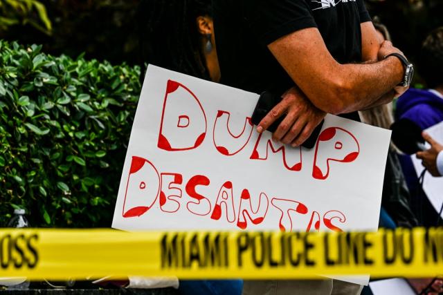 Protesters gather outside the  Four Seasons Hotel in Miami on 24 May as the governor holds  fundraising events ahead of his presidential candidacy announcement. (AFP via Getty Images)