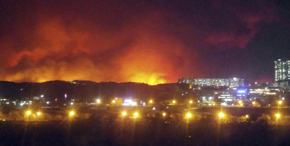 In this Thursday, April 4, 2019 photo, a wildfire burns in Goseong, South Korea. A few people died and thousands were evacuated after strong winds fanned a large fire Friday burning in a mountainous South Korean province that hosted the 2018 Pyeongchang Winter Olympics, officials said. (Lee Jong-geun/Yonhap via AP)