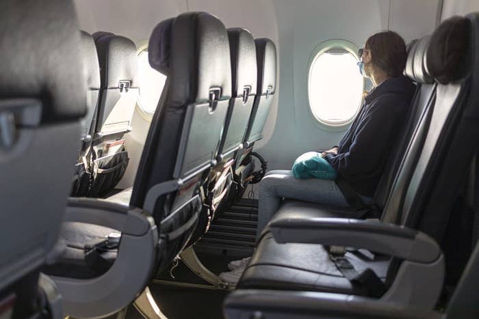 A woman looking out the window on a plane