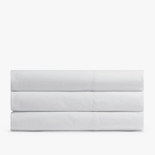 three folded white top sheets for bed against white background