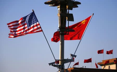 U.S. (L) and Chinese national flags flutter on a light post at the Tiananmen Square ahead of a welcoming ceremony for U.S. President Barack Obama, in Beijing, November 12, 2014. REUTERS/Petar Kujundzic