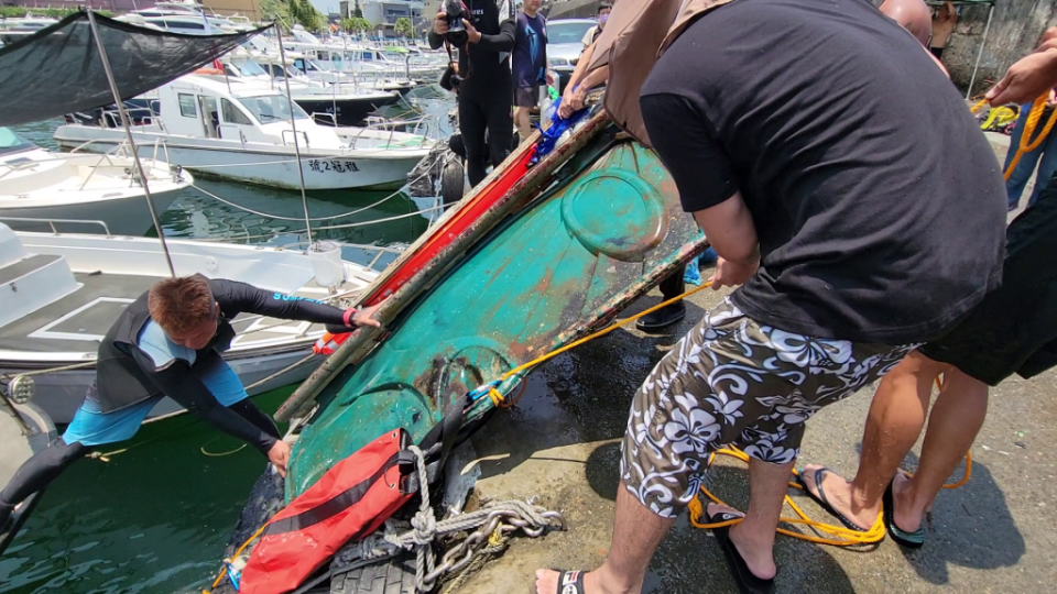 新壽慈善基金會在基隆沿海連清四天海廢達一點五噸，志工將行動廁所的門費力扯拉上岸。（記者王慕慈攝）