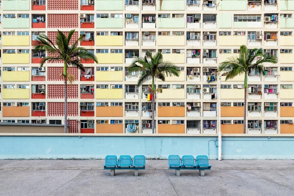 Some benches in front of colorful facades of public housing complexes in Hong Kong