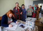 Local residents stand in line to receive ballot papers before casting their votes for the presidential election at a hospital in the village of Kozhushna, outside Chisinau, Moldova, October 30, 2016. REUTERS/Gleb Garanich