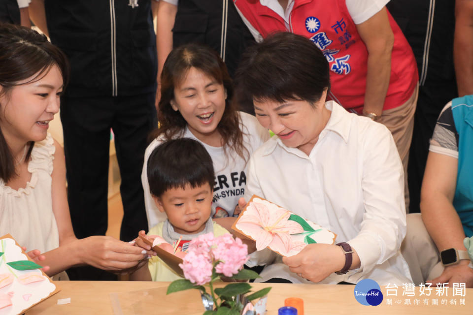 盧秀燕與兒童一起製作玫瑰百合花圖案的母親節卡片。