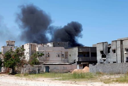 Smoke rises during a battle between Libyan forces allied with the U.N.-backed government and Islamic State fighters in neighborhood Number Two in Sirte, Libya August 16, 2016. REUTERS/Ismail Zitouny