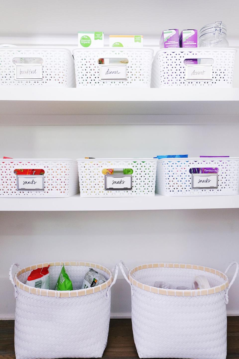 Organized Kitchen Pantry with Labeled White Baskets on Shelves and Large Floor Baskets