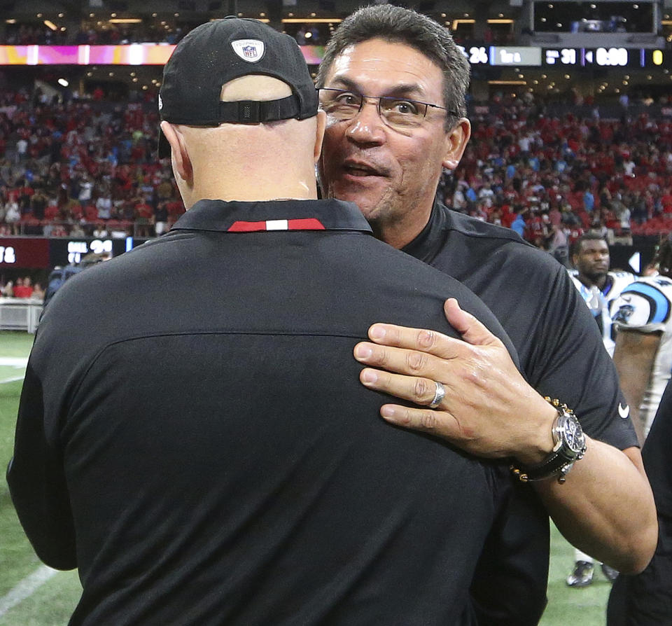 Carolina Panthers head coach Ron Rivera, right, speaks with Atlanta Falcons head coach Dan Quinn after an NFL football game, Sunday, Sept. 16, 2018, in Atlanta. The Atlanta Falcons won 31-24. (AP Photo/John Bazemore)