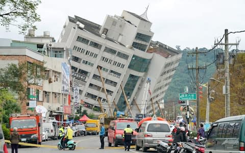 Rescue and emergency workers block off a street where a building 