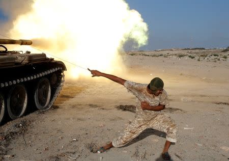 A fighter of Libyan forces allied with the U.N.-backed government fires a shell with Soviet made T-55 tank at Islamic State fighters in Sirte, Libya, August 2, 2016. REUTERS/Goran Tomasevic