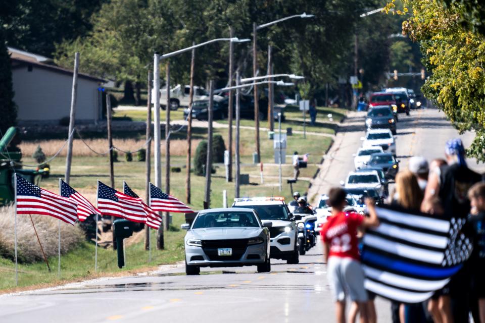 Vehicles drive during the funeral procession for Algona Police Department Officer Kevin Cram on East McGregor Street on Wednesday, September 20, 2023 in Algona.