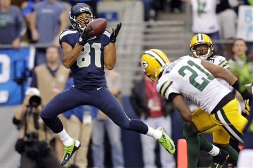 Seattle Seahawks wide receiver Golden Tate (81) catches a pass for a touchdown ahead of Green Bay Packers cornerback Charles Woodson (21) in the first half of an NFL football game, Monday, Sept. 24, 2012, in Seattle. (AP Photo/Stephen Brashear)